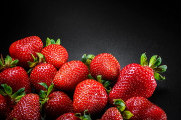 Fresh organic Strawberries with green leaves on black elegant background