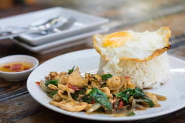 Fried chicken with basil and egg on rice.