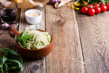 Vegetarian pesto pasta with cheese in bowl and Italian food ingredients