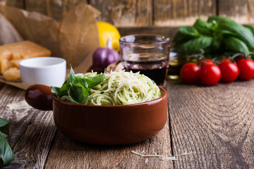 Vegetarian pesto pasta with cheese in bowl and Italian food ingredients