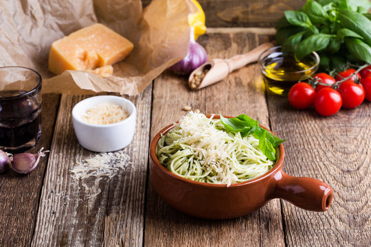 Vegetarian pesto pasta with cheese in bowl and Italian food ingredients