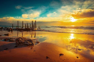 Schilderijen op glas Port Willunga beach with jetty pylons at sunset © myphotobank.com.au