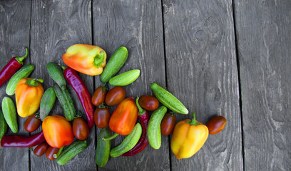  fresh vegetables, cucumbers, tomatoes, peppers, on a wooden table