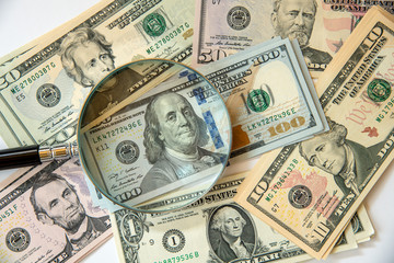 US Dollar banknotes under magnifying glass