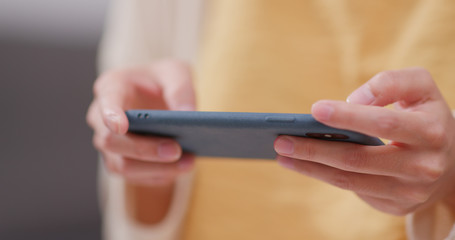 Woman play game on cellphone at home