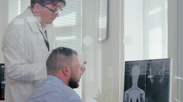 Joint work of two neurologists at computer in medical research center. Doctors use computer to view picture of brain. Digital diagnostics in medicine