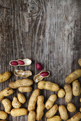 Peanuts in a wooden bowl on an old table. Delicious and healthy nuts close-up.Place for your text.