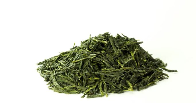 heap of sencha green tea leaves rotating on turntable isolated on white background front view, seamless loop
