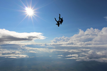 Fototapeta na wymiar Two skydivers are falling in the amazing sky.
