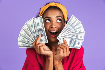 Image of Cheerful african woman in dress holding money