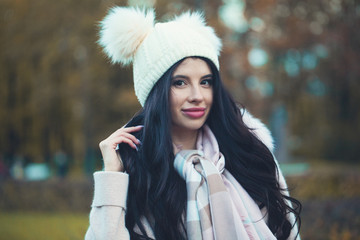 Pretty autumn woman in white hat outdoor. Beautiful girl in fall park