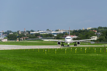 Fototapeta premium airplane on runway, green grass, blue sky