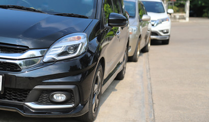 Closeup of front side view of black car parking beside the street.