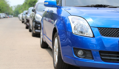 Closeup of front side view of blue car parking beside the street.
