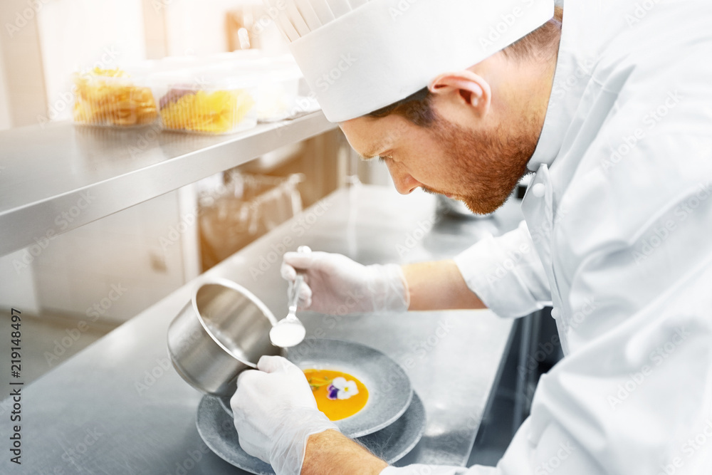 Poster food cooking, profession and people concept - happy male chef cook serving plate of soup at restaurant kitchen