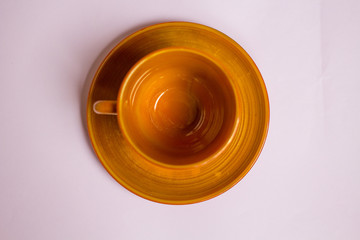 Obraz na płótnie Canvas empty brown clay tea cup on lilac background. top view