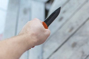 A knife in a man's hand. The concept of cruelty, violence, aggressive criminal behavior.
