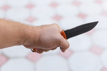 A knife in a man's hand. The concept of cruelty, violence, aggressive criminal behavior.