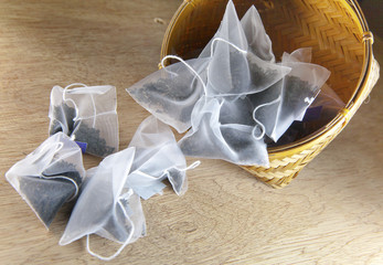 bags of elite tea in silk fabric packing on a wooden background