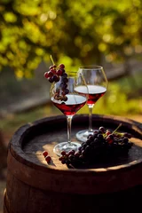 Photo sur Plexiglas Vin Deux verres de vin rouge avec une bouteille sur un tonneau en bois