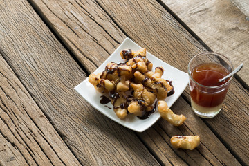 Deep-fried dough stick and coffee on wooden to creative for design and decoration on background.Copy space.