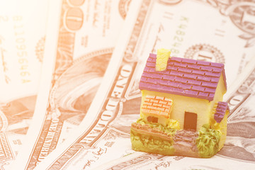 A model of a house in the background of money. Toned