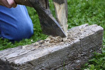 Hand with axe, wood chips fly