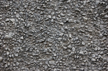 the wall consists of small gray stones in a chaotic manner