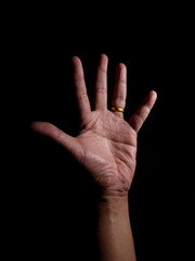 Hand with ring at ring finger isolated in black