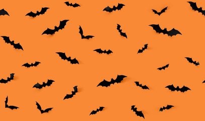 halloween decorations concept - seamless pattern with black paper bats on orange background