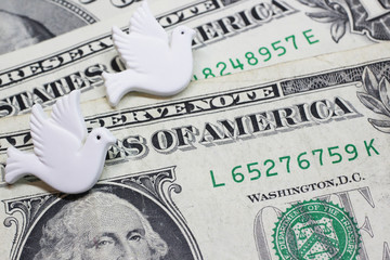 Two badges in the form of pigeons on the background of money