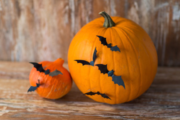 halloween and holidays concept - pumpkins with bats or party decorations