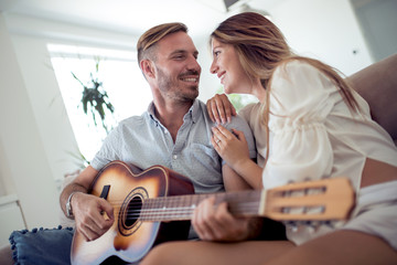 Couple playing acoustic guitar