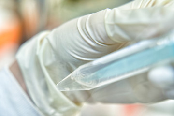 Close up of the woman researcher using pipette to resuspension of cells line in the research of...