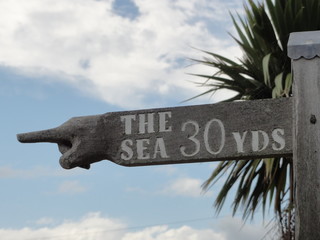 Wooden sign pointing to the sea