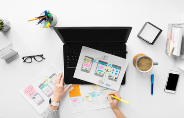 app design, technology and business concept - web designer or developer with sketches and laptop...