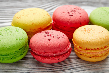 colorful macarons over   wood table. top view
