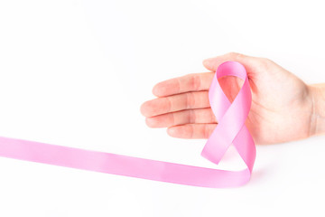 Pink ribbon symbol for breast cancer awareness concept in woman hand over white background with copy space for text, logo, or wordings insertion or decoration
