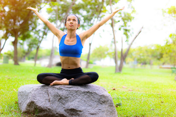 Athlete girl practising yoga in the park, woman health improvement
