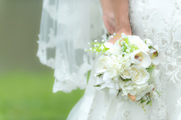 Bride holds a wedding bouquet.  Bride wedding white dress in the garden.  Nature Background.