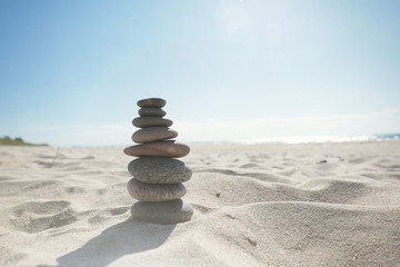 Pyramid of sea stones on the sand by the sea