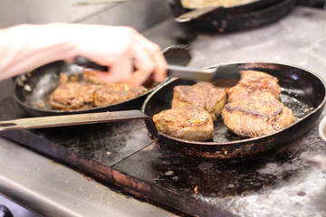 cooking fresh steak in kitchen