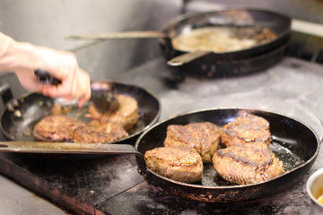 cooking fresh steak in kitchen