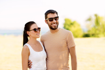 people and relationships concept - happy couple in sunglasses outdoors in summer