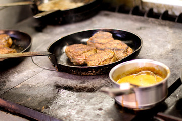 cooking fresh steak in kitchen