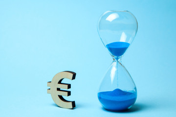 Hourglass and symbol of money euro on blue background