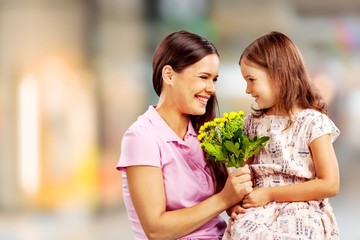 Young woman with little girl and beautiful flowers outdoors