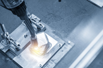 The welding robot machine for welding automotive part in the light blue scene.Industrial 4.0...