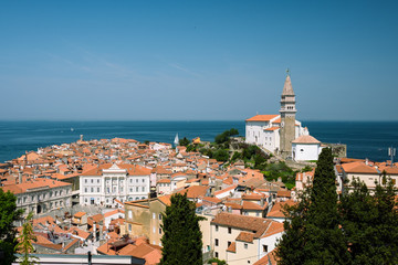 Aerial shot of orange roofs of Piran fishermen town with church in Slovenia