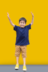 Asian Cute boy smile and stand with yellow wall background